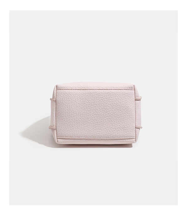 Compact pebbled leather-look shoulder bag with crossed silver-toned metal front closure, short top handle, and long, detail