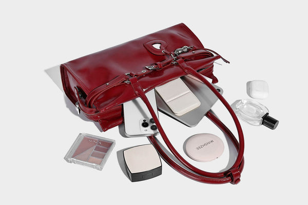 Structured rectangular glossy tote shoulder bag with belt buckle front strap and dangling charm hardware, detail view 20