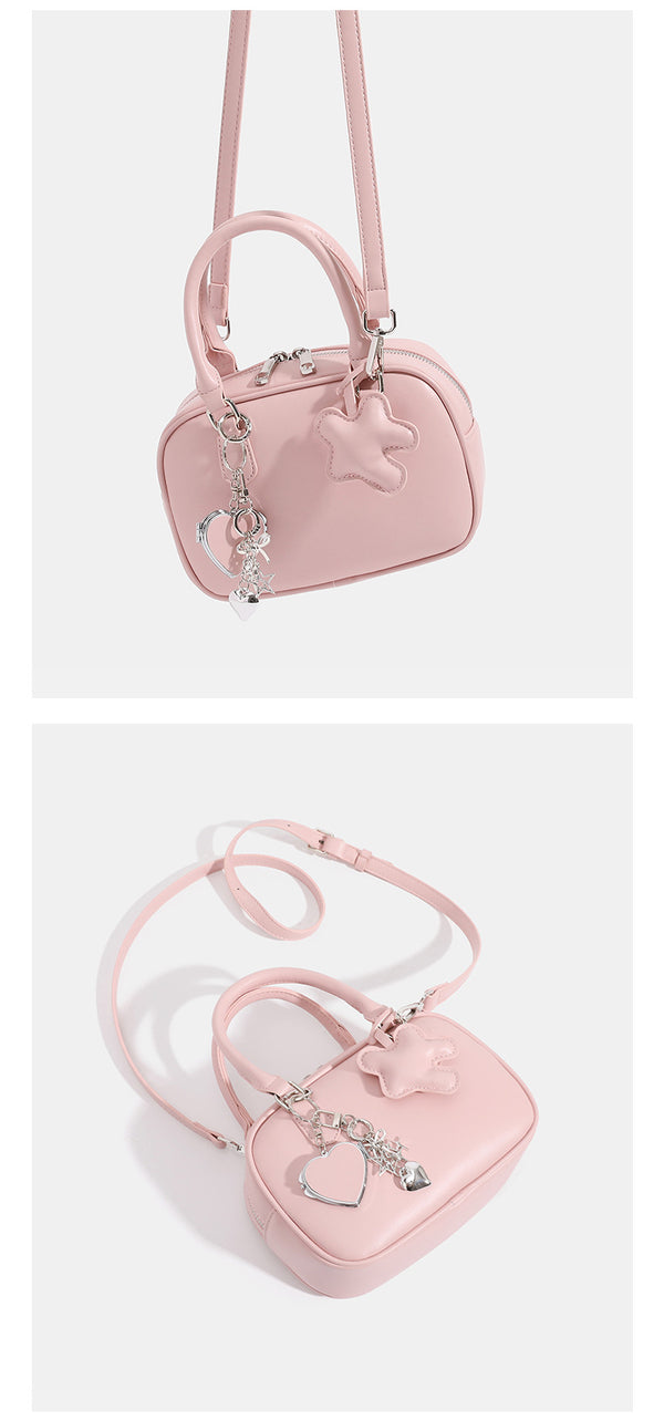 Small structured rounded-rectangle mini handbag with glossy leather-look finish, top zip closure, silver-tone hardware, and