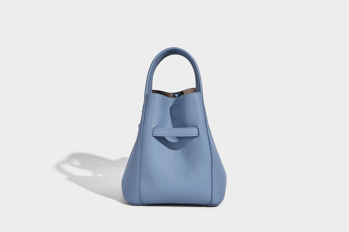 Small structured pebbled bucket tote bag with dual top handles, silver turn-lock front pocket, and detachable shoulder strap