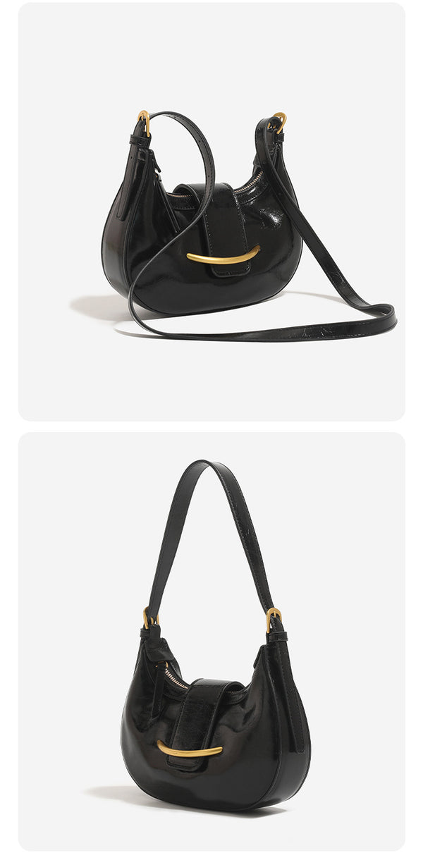 Compact crescent hobo shoulder bag with glossy synthetic finish, curved gold-tone front bar hardware, zip-top closure, and